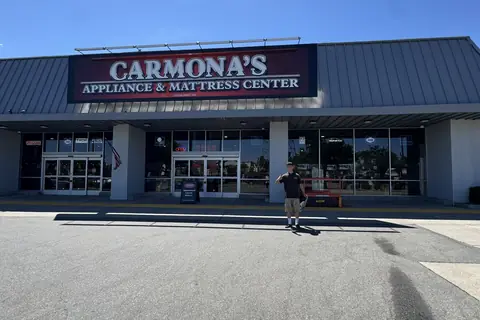 A crew member giving a thumbs up in front of a long retail storefront
