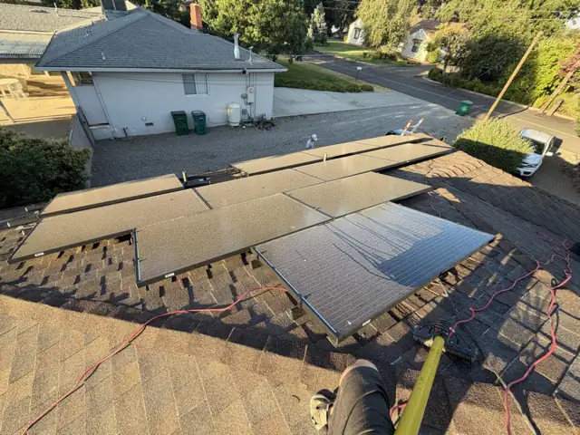 Rooftop solar panels dulled by a gray film of dust, before cleaning