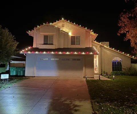 The same house at night after we installed red and white lights along the roofline